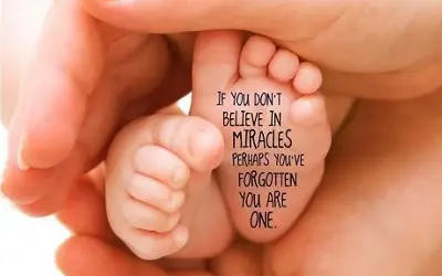 baby feet in the palm of a hand